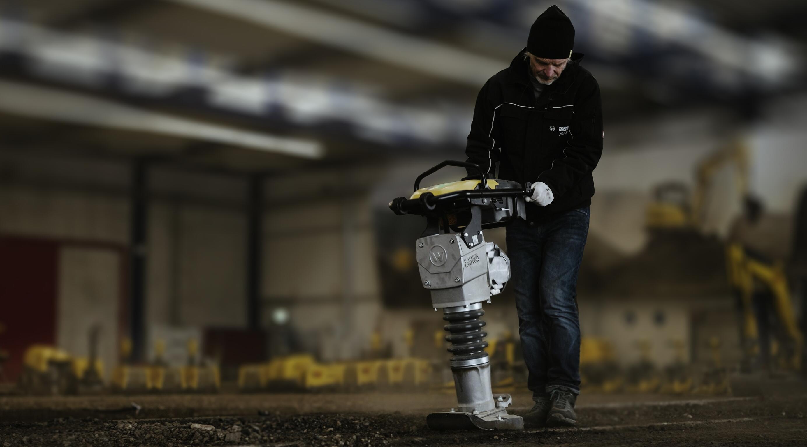 Pracownik obsługujący ubijak do zagęszczania gruntu w sali szkoleniowej do prac budowlanych