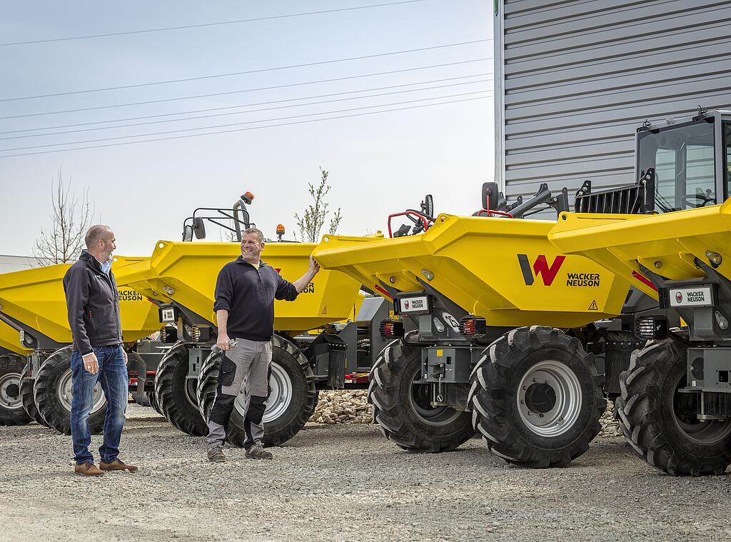 two persons in front of some wacker neuson dumper