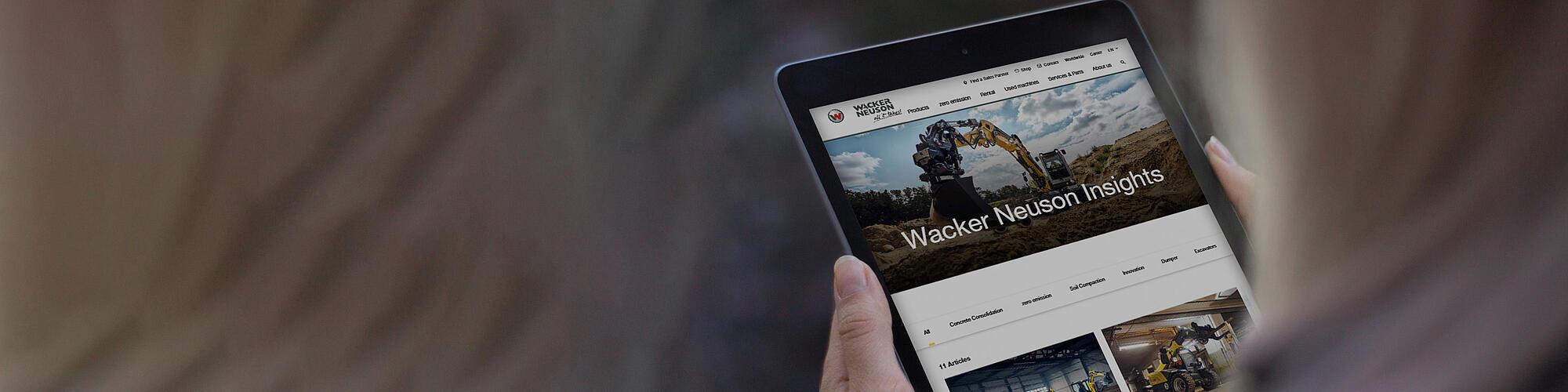 women reads articles from Wacker Neuson Insights on tablet