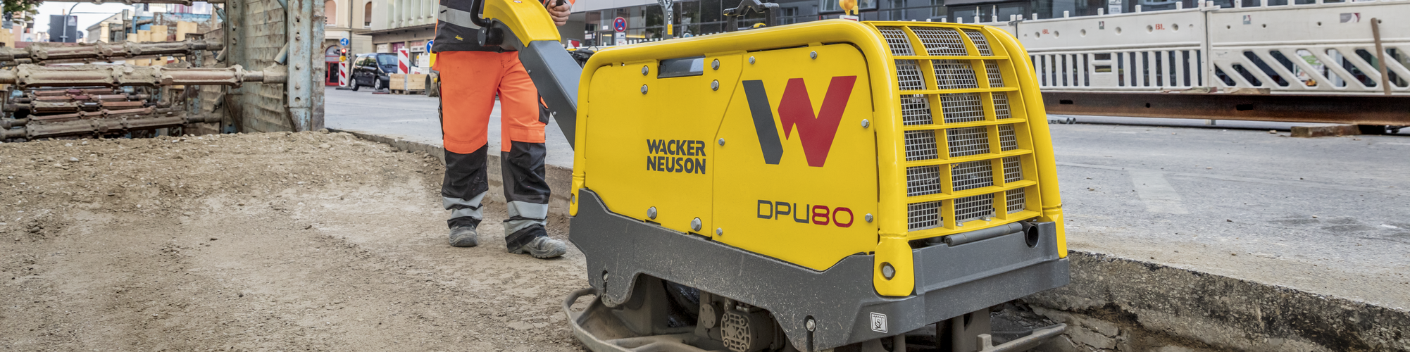 A Wacker Neuson vibratory plate in action on a construction site in the city.